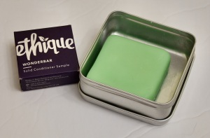 On the left, a small box with the words ethique wonderbar, solid conditioner sample. On the right a green square conditioner bar in an open metal tin.